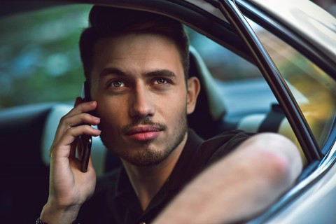 Handsome man sit in the back seat of the car and use a phone