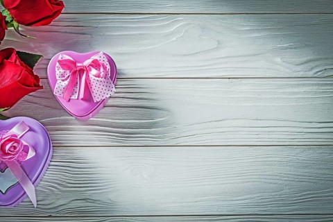 Heart-shaped metal present boxes red roses on wood board holidays concept