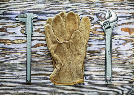 Vernier caliper adjustable spanner safety gloves on wooden board