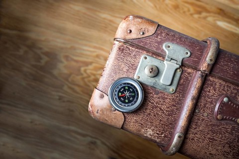 Old vintage suitcase with a compass seen from above, concept for travel, adventure and finding the