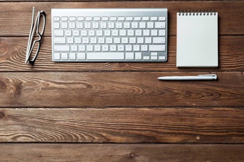 Still life of office workspace with supplies. Flat lay old wooden desk with white computer