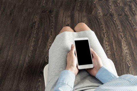 Business woman with cell phone on her lap