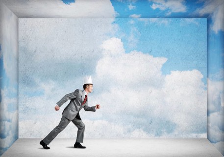 King businessman in elegant suit running in empty room with blue sky on wall