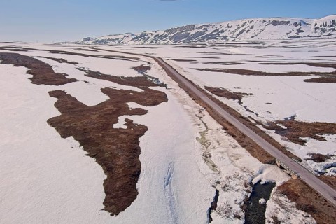 Aerial view of plateau landscape with snow covering the ground and Austertanaveien road 890 in