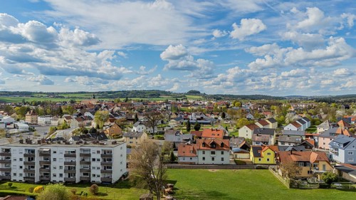 Urban landscape with varied roofs and green surroundings under a changing sky, Mitterteich, Upper