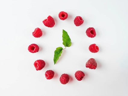 Clock made of berries leaves and raspberries. Isolated on white. Top view or flat lay. Health,