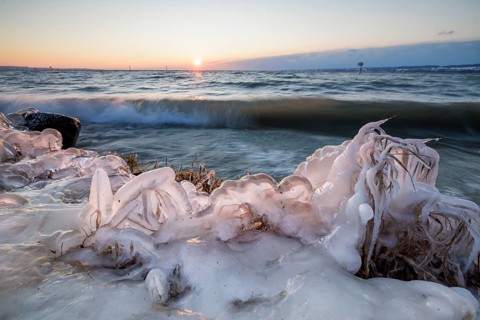 Snow-covered coastline, ice plants and waves at dusk, sunrise in the background, Hörnle, Constance,