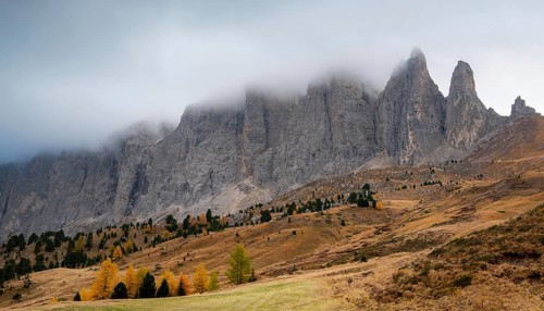 Mountain landscape of dolomites covered with fog Italian alps in autumn. Nature scenery Italy.