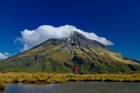 A man in front of Mount Taranaki in New Plymouth, New Zealand, Oceania