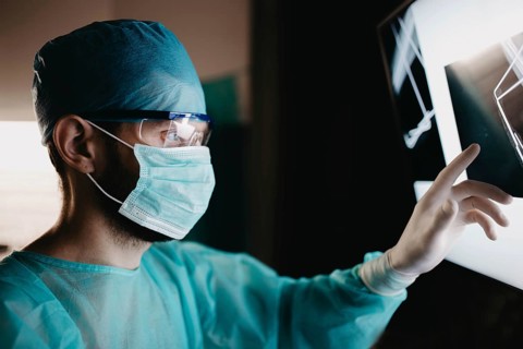 Doctor analyzing x-ray images with focused attention and protective gear