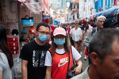 24.01.2020, Singapore, Republic of Singapore, Asia, Pedestrians wearing face masks stroll through a