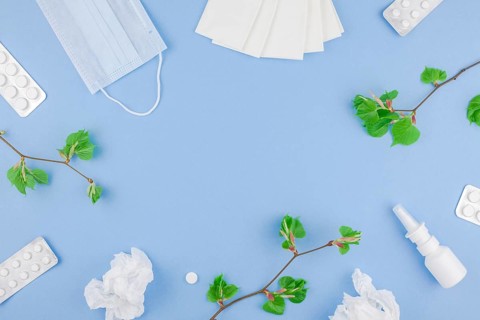 Creative flat lay concept of seasonal spring pollen allergy with napkins, pills, face mask, drops