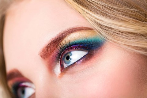 Close up portrait of a beautiful young blond model with bright make up. Close up of abstract