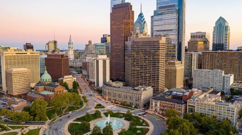 Vehilce traffic circles around the fountain at Logan Square in the bustling urban core of