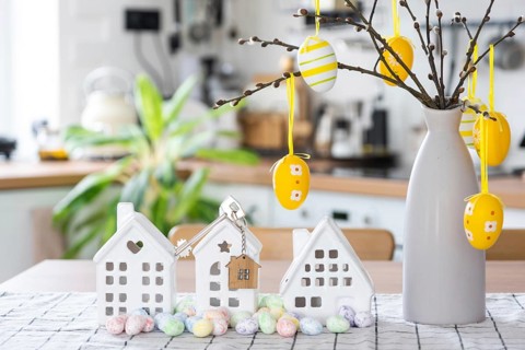 Key to house of cozy home with Easter decor with rabbit and eggs on table of kitchen. Building,