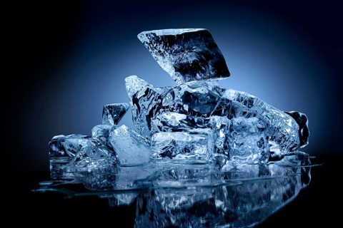 Frozen block of ice with blue tinted background