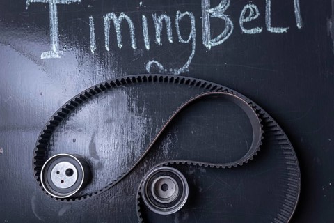Timing belt on a blackboard with chalk writing and gears