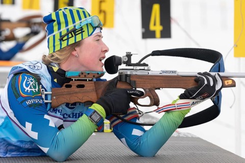 Sportswoman biathlete Legostaeva Anastasia rifle shooting in prone position. Biathlete in shooting