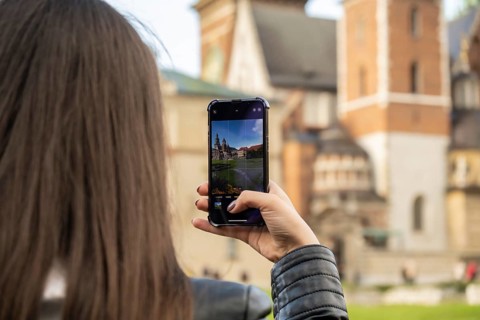 Female traveler in historical places looks around courtyard of landmark and shoots short video on