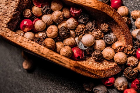 Different kind of peppercorns in a wooden spoon