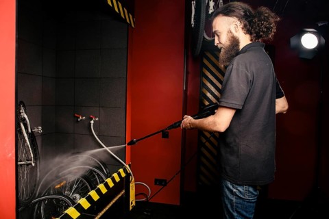 Services professional washing of a bicycle in the workshop. Close-up of hand Young Caucasian