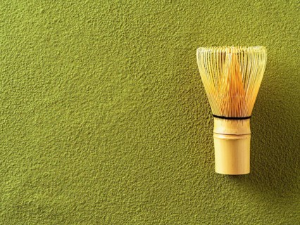Powdered green tea Matcha background and bamboo whisk Chasen. Copy space for text or design