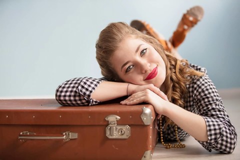 Beautiful pin up girl. Portrait of a beautiful retro woman. Girl with an old suitcase