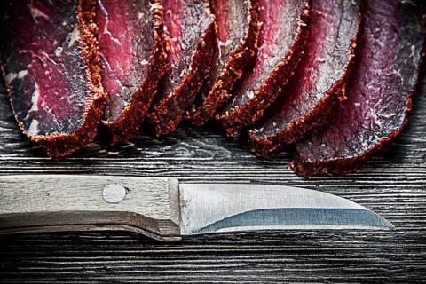 Sliced meat knife on wooden board food concept