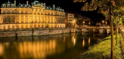 Night panoramic view with the Rohan Palace and the river Ill, with building and yellow lights