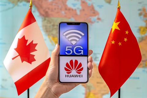 Calgary, Alberta, Canada. Sep 8, 2020. A person holding an iPhone with a 5G and Huawei logo on the