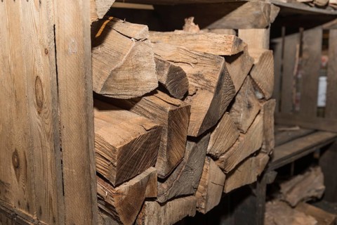 Old wooden box for storing logs ready for the stove - close-up of firewood