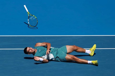 Spanish tennis player Carlos Alcaraz (ESP) diving for forehand shot and falling to the ground at