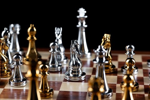 Gold and silver chess figures standing on chessboard. Intellectual and tactic game. Strategy