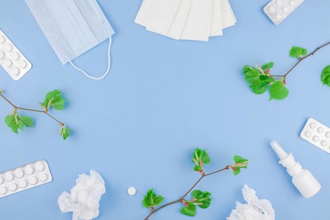 Creative flat lay concept of seasonal spring pollen allergy with napkins, pills, face mask, drops