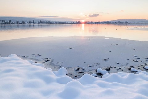 Snow-covered shores of a frozen lake at sunset, quiet and peaceful atmosphere, Seegarten,