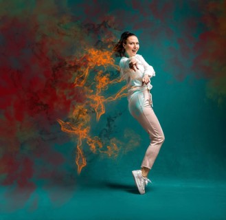 Young and beautiful dancer posing in the studio in front of a colourful background
