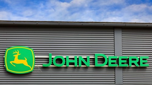 John Deere logo outside on building exterior with blue sky and clouds. Salo, Finland. June 25, 2023