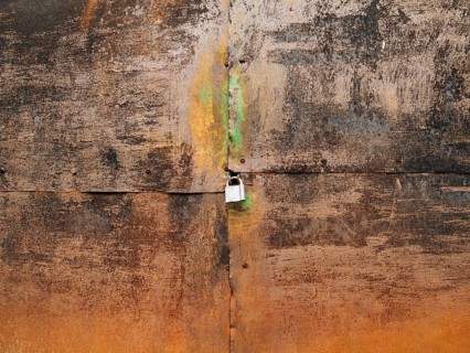 Metal rusty gate and padlock. Texture of rusty metal