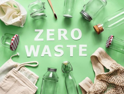 Zero waste concept. Textile eco bags, glass jars and bamboo toothbrush on green background with