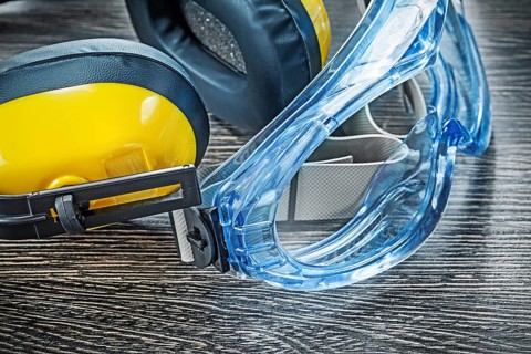 Protective spectacles earmuffs on wooden board