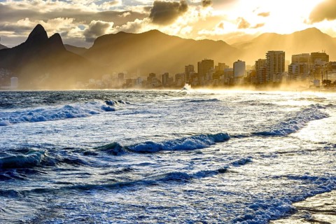 Summer sunset with cloudy sky with Two Brothers hill and Vidigal slum view from Ipanema beach at