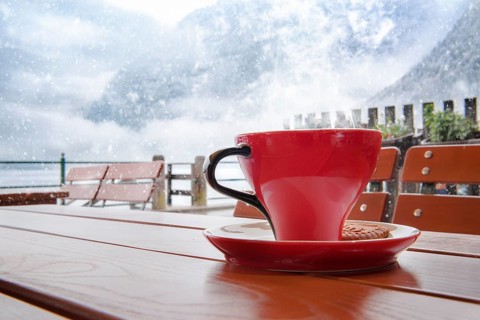 Relaxing moment with a hot cup of coffee, on a table, at an Austrian restaurant, in Hallstatt, with