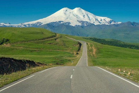 Road leading to mount Elbrus with green meadows at summer. North Caucasus, Russia, Europe