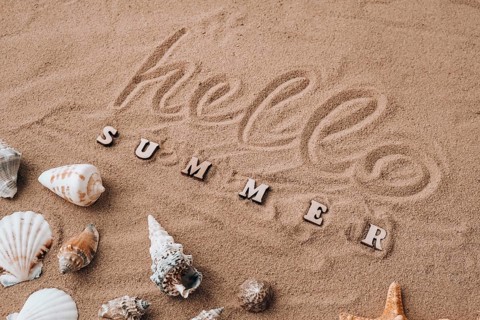 Composition with text HELLO SUMMER seashells, pebbles, mockup on sand background. Blank, top view,