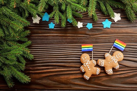 Christmas background of gingerbread man with flag spruce branches and colorful sugar snowflakes on