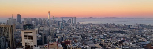 Orange hues seem to bounce off the tallest building as night comes to the San Francisco Bay area