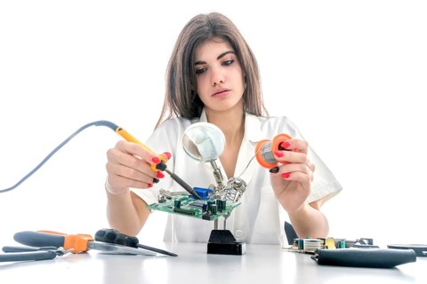 Woman Electronic Technician Repair Electronic Equipment using Electric Soldering Iron