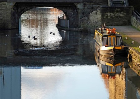 An old traditional narrow boat moored on the canal near brighouse basin in west yorkshire with