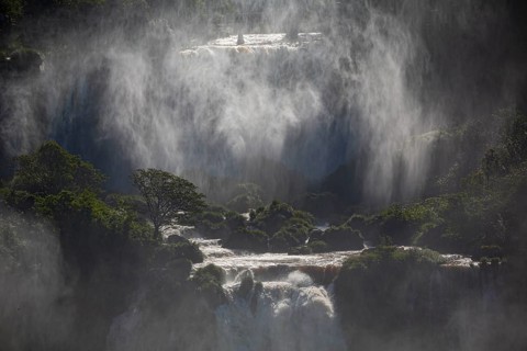 Mystical view to waterfall cascades with a wall of spray and sunlight, Iguazu Falls, Misiones,