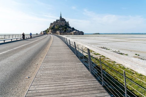 Mont Saint Michel, France, July 25, 2018: View of Mont Saint-Michel against sky. Cyclists on the